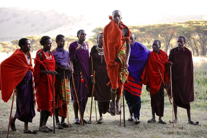 A group of people standing in a field with sticks.
