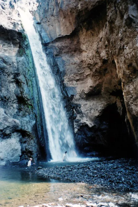 A waterfall in the middle of a rocky canyon.