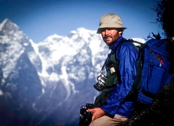A man with a backpack standing on top of a mountain.
