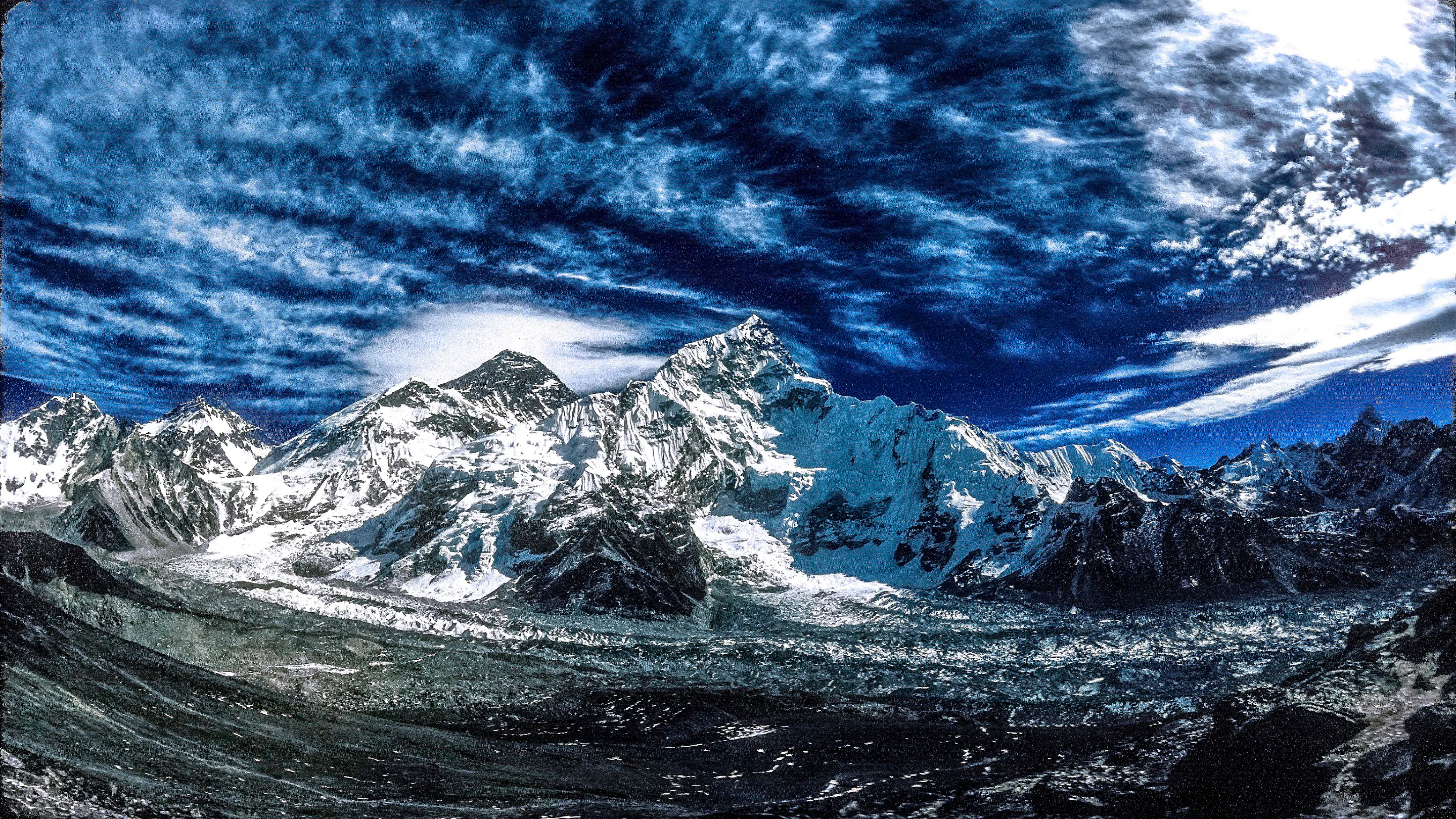 A view of a mountain range with clouds in the sky.
