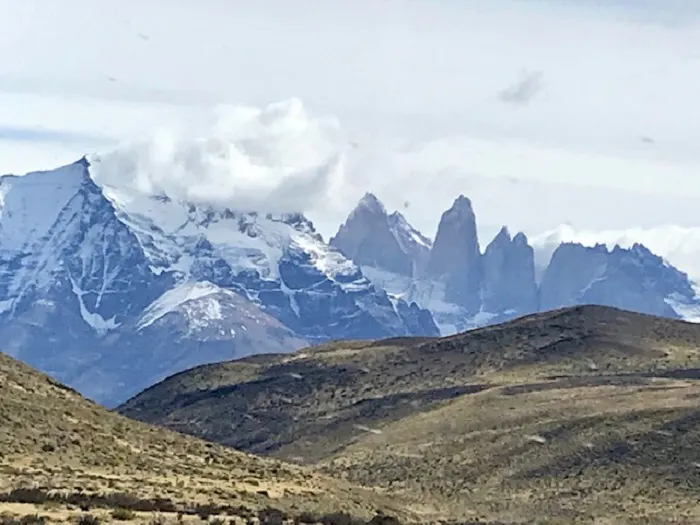 A mountain range with snow capped mountains in the background.