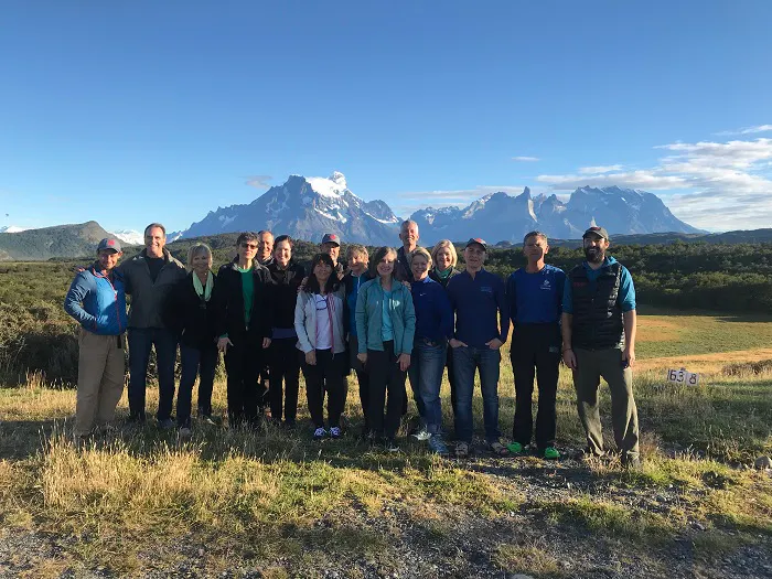 A group of people posing for a photo in front of mountains.