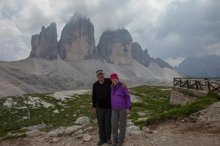 A man and woman standing in front of a mountain.