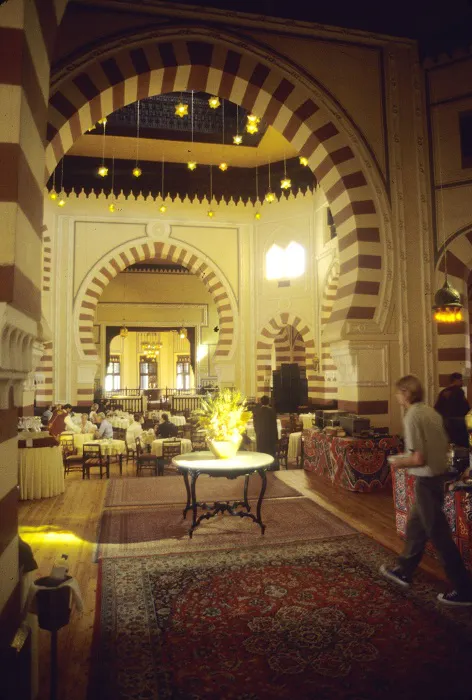 The interior of a large building with arches and carpets.