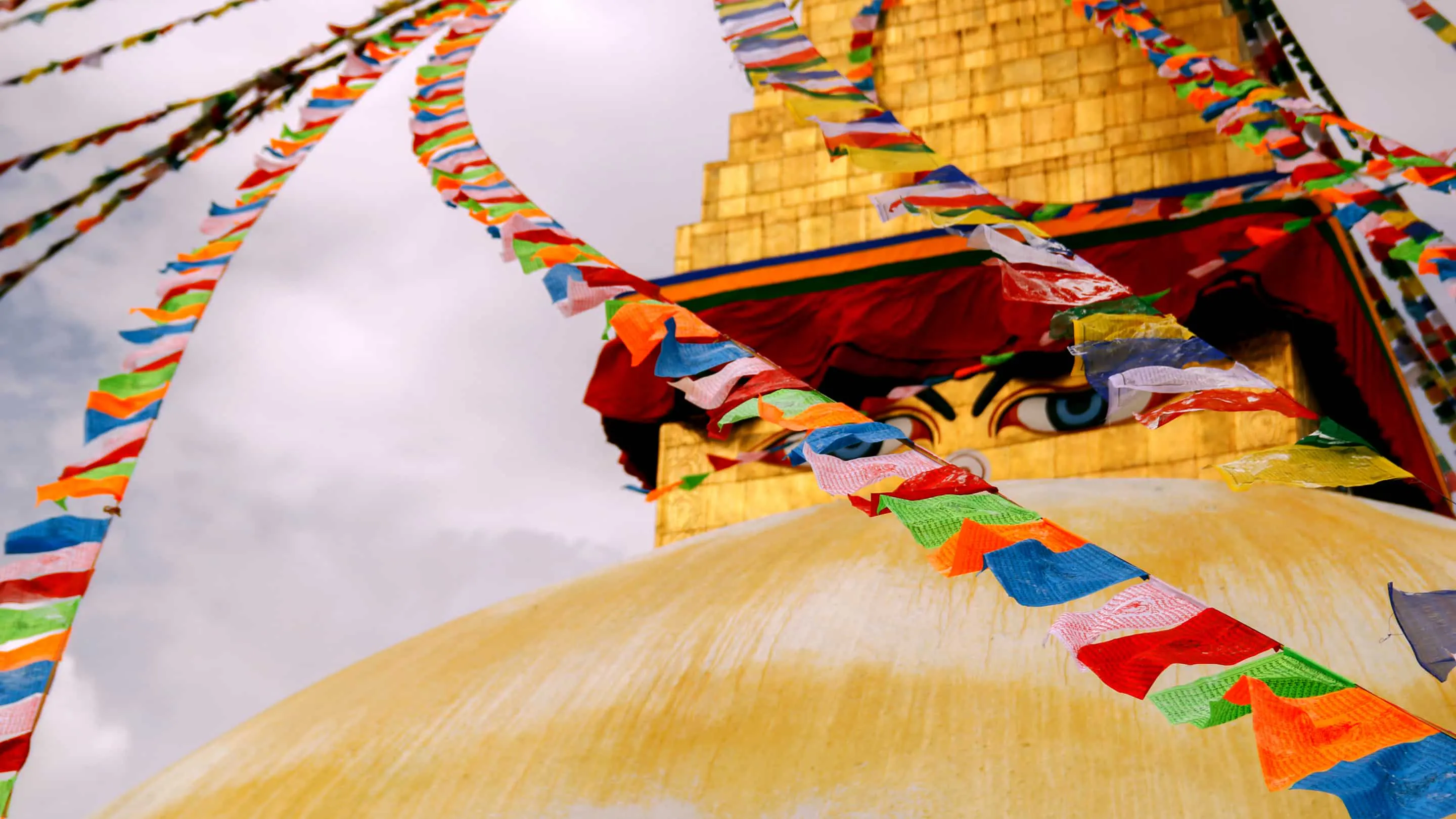 Colorful flags hanging from the top of a temple.