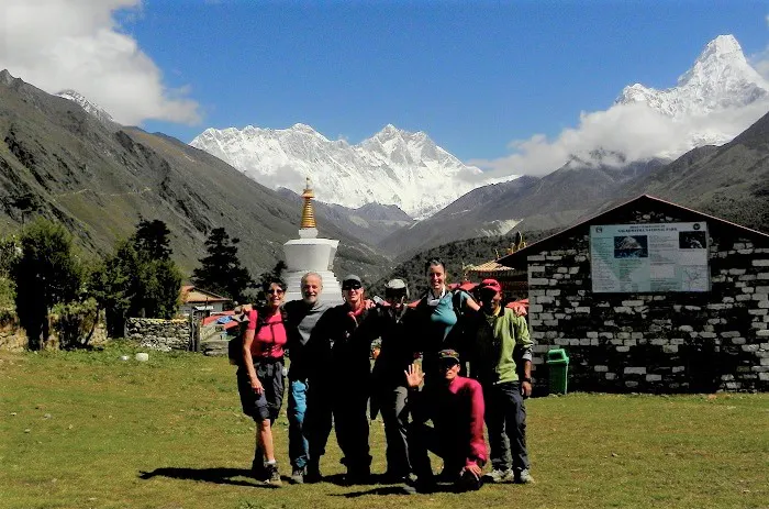 A group of people posing in front of a mountain.