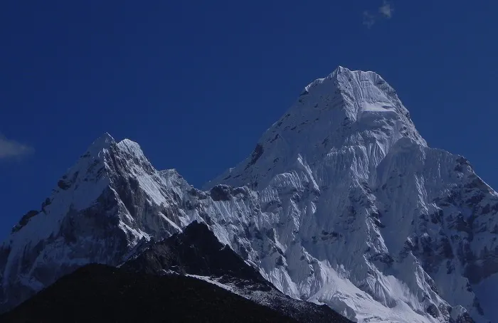 A snow covered mountain with a blue sky in the background.
