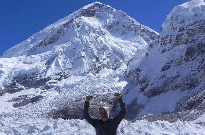 A man standing in front of a snow covered mountain.