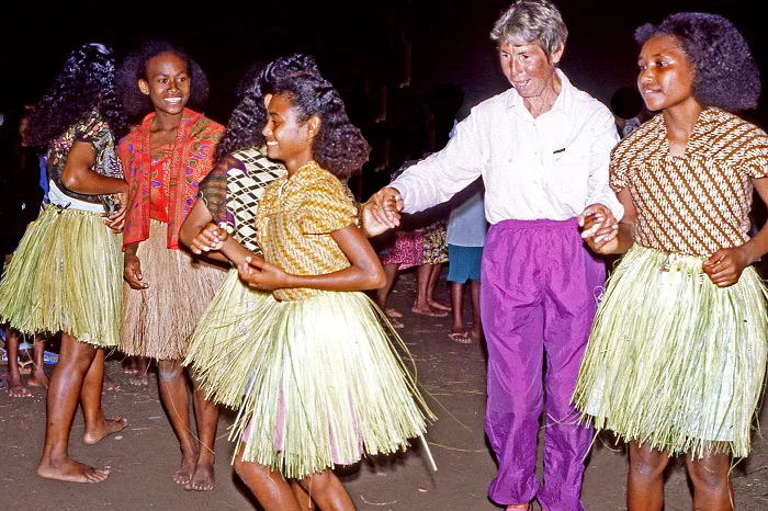 A group of people dancing in grass skirts.