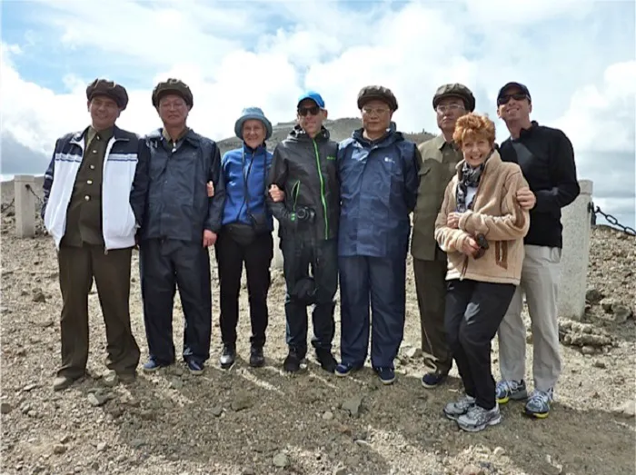 A group of people posing for a photo on a mountain.