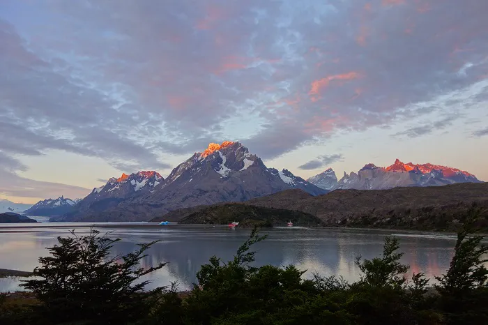 A lake with mountains in the background at sunset.