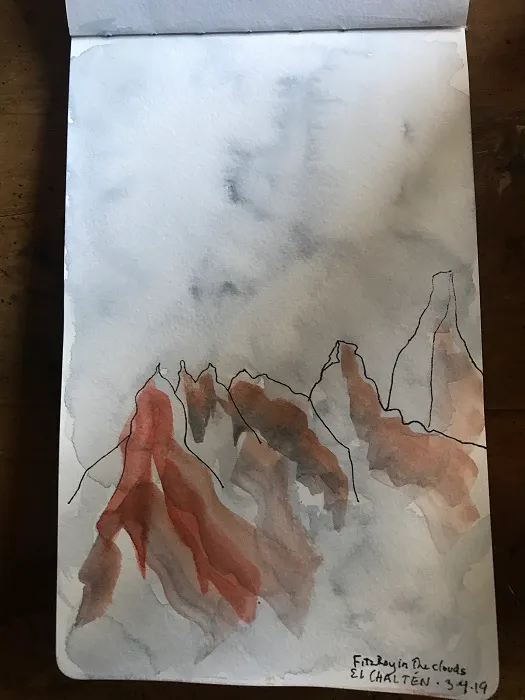 A watercolor sketch of mountains on a table.