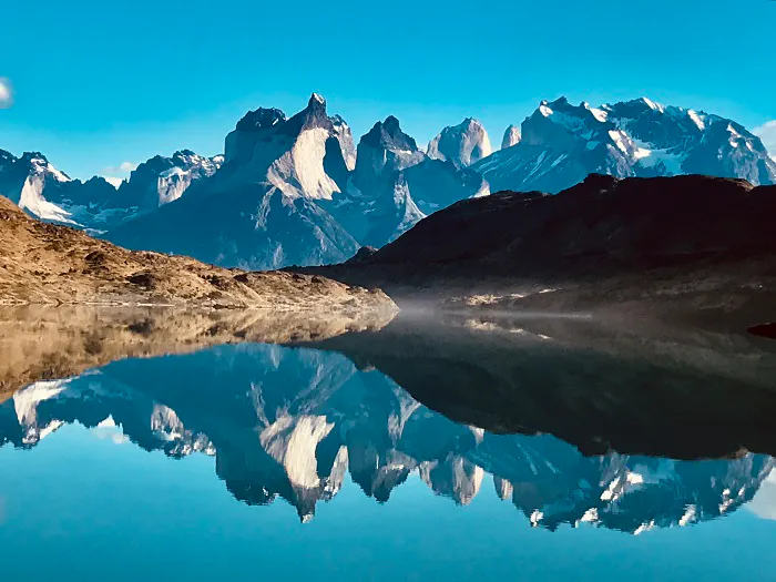 A mountain range is reflected in a lake.