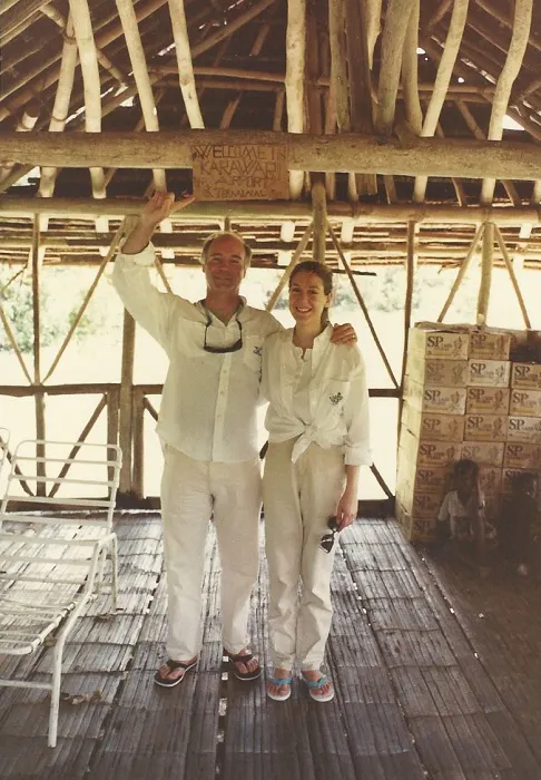 A man and woman standing in a wooden hut.