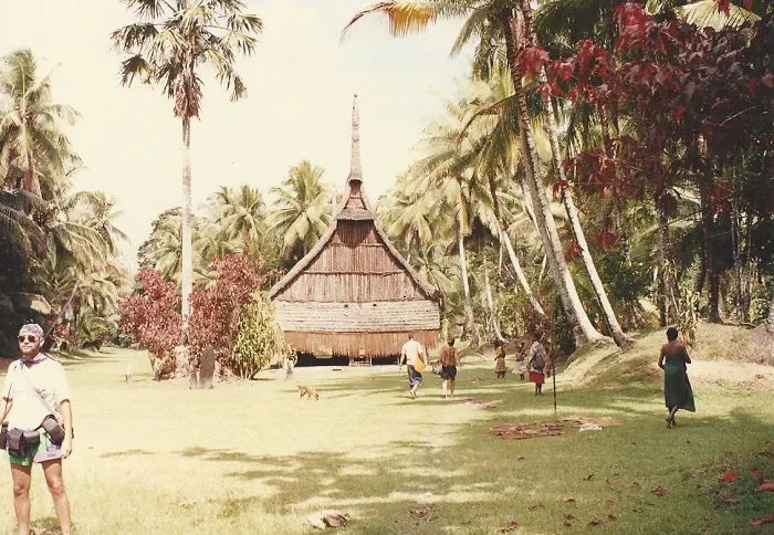 A group of people standing in front of a wooden building.