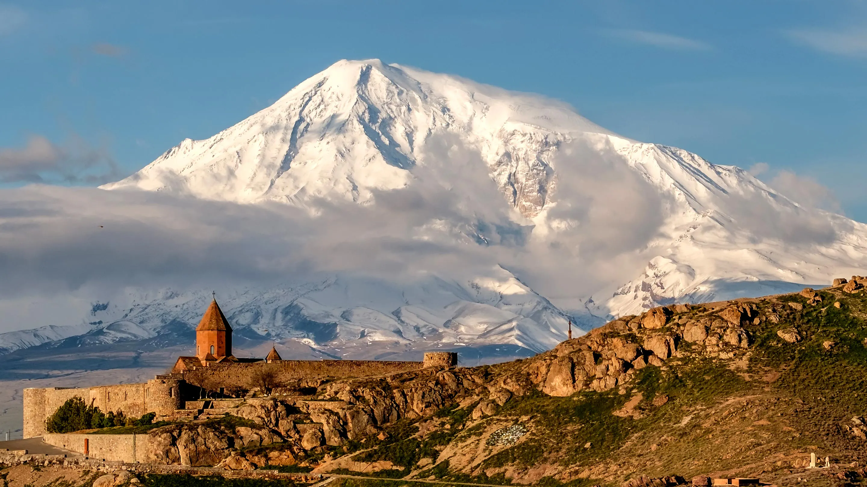 A mountain with a castle on top of it.