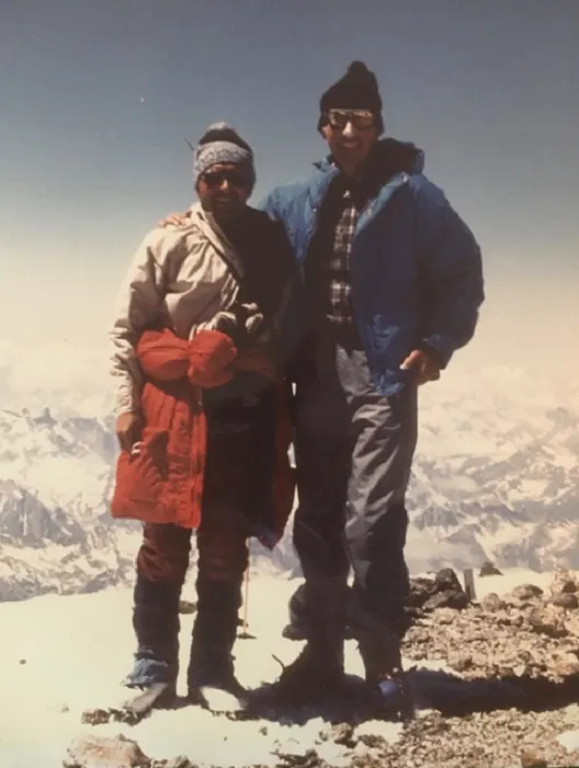 Two people standing on top of a mountain.