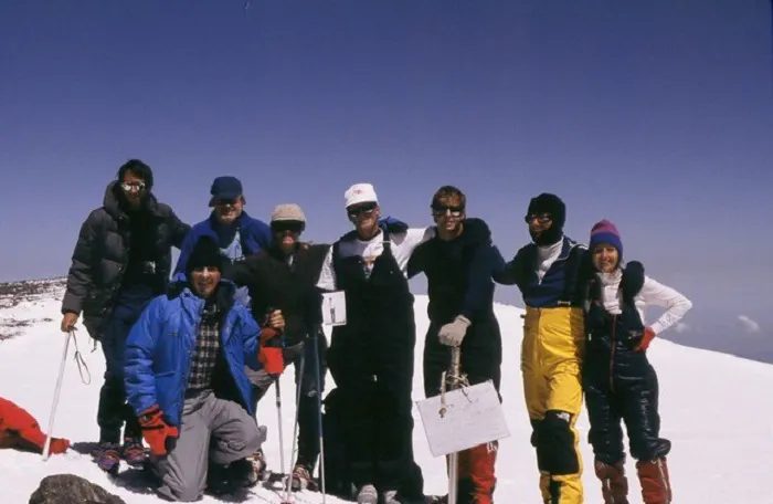 A group of people standing on top of a snowy mountain.