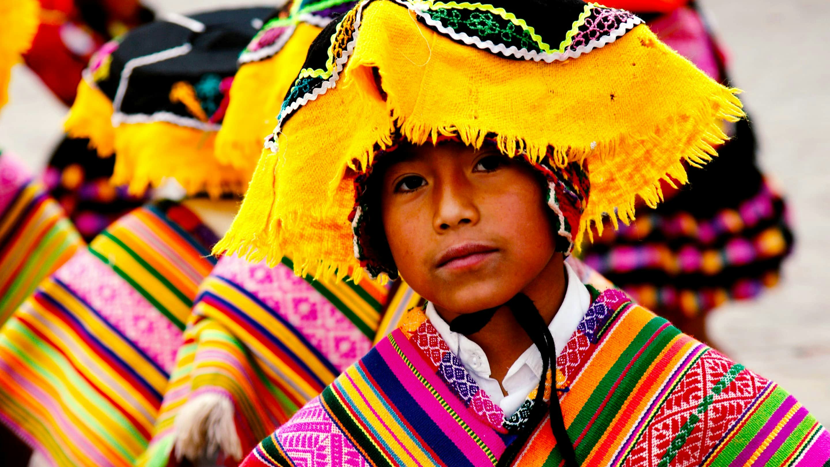 A group of children wearing colorful clothing and hats.