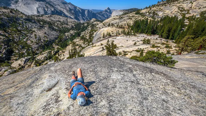 A man is laying on a rock in yosemite national park.
