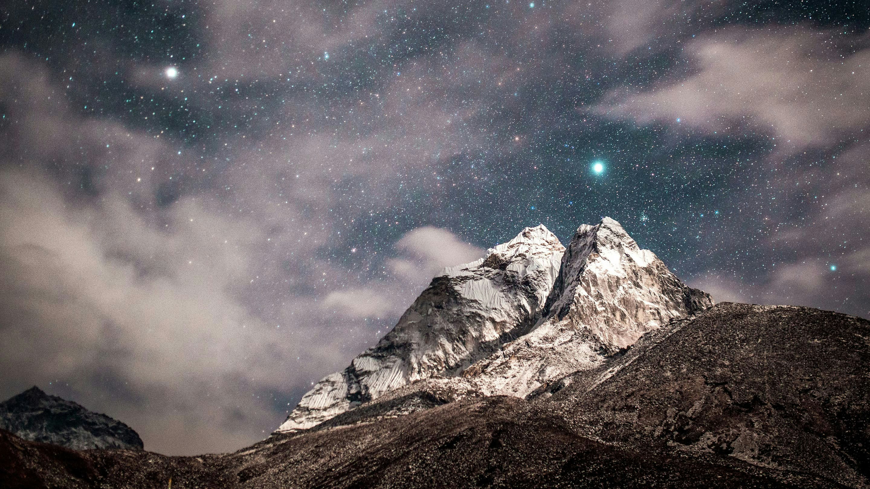 A mountain with a starry sky above it.