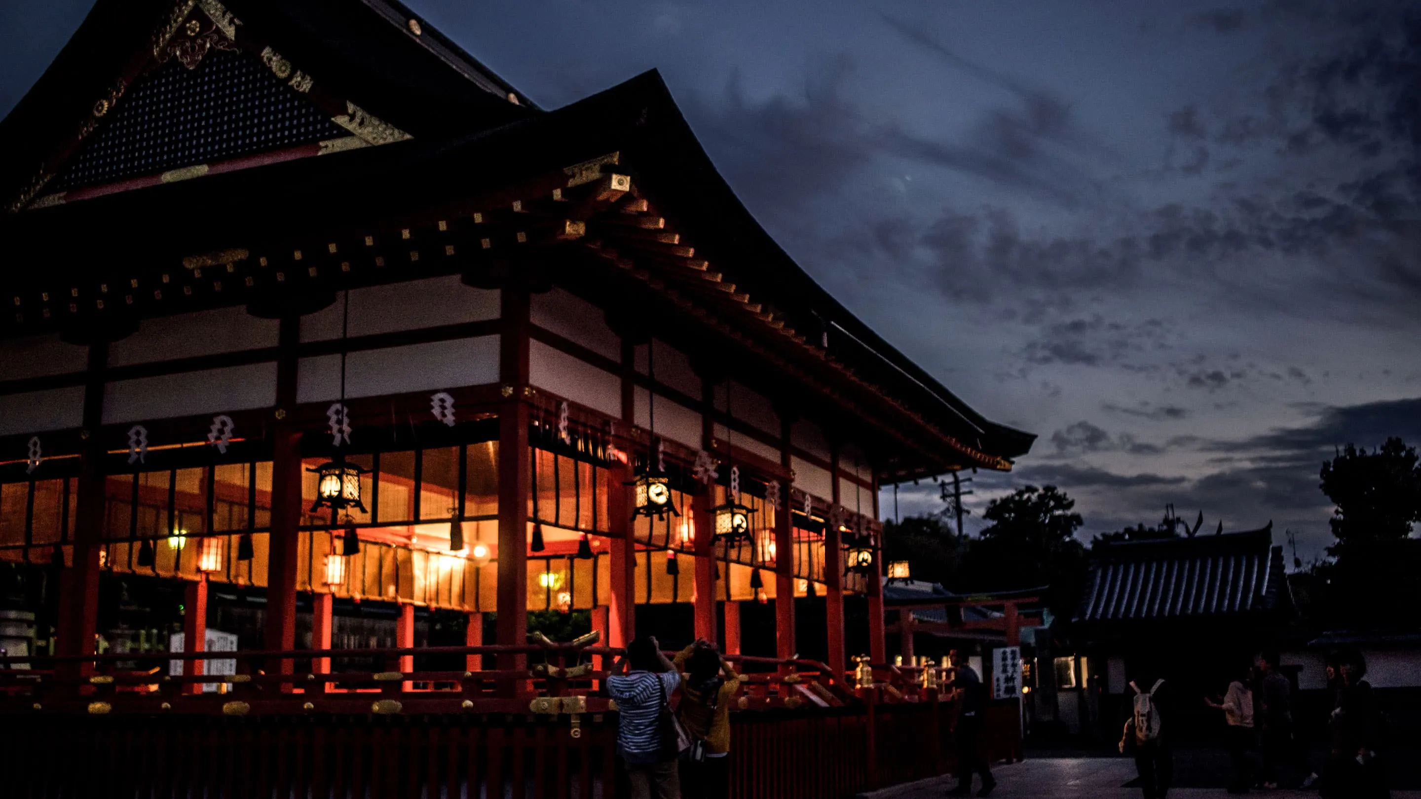 A shrine lit up at dusk in kyoto, japan.