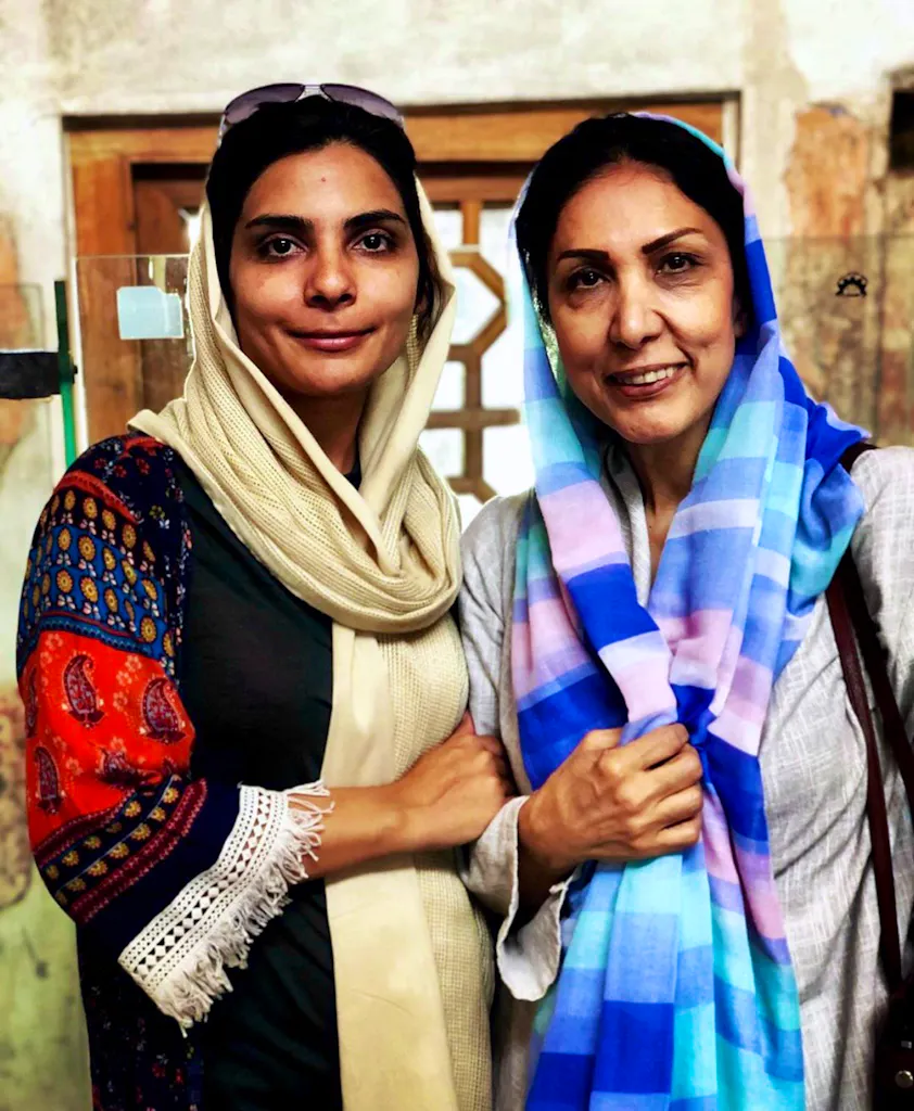 Two women standing next to each other in a room.