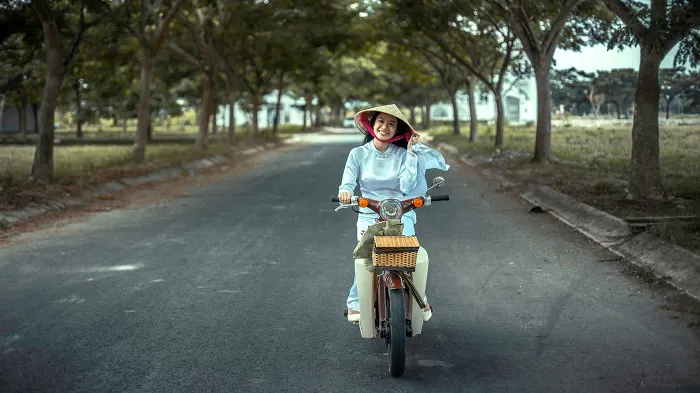 A woman riding a bicycle down a country road.