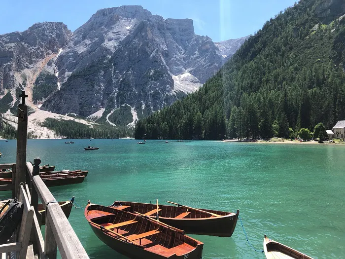 A group of wooden boats docked in a lake.