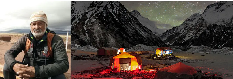 A man is standing in front of a tent in the mountains.