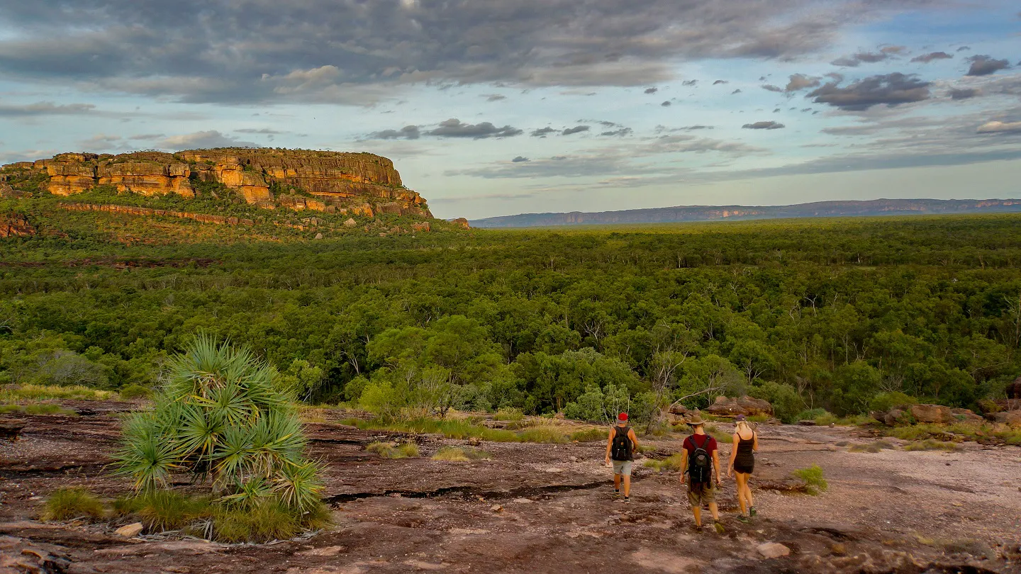 A group of people standing on a rocky cliff at Kakadu National Park, Australia.