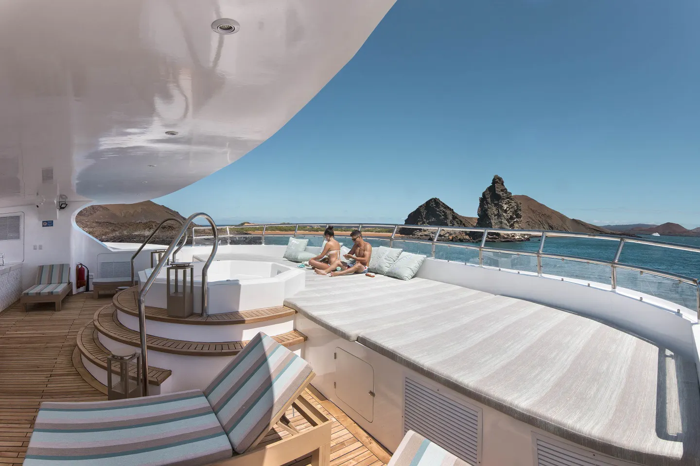 The deck of a yacht with two people on it.