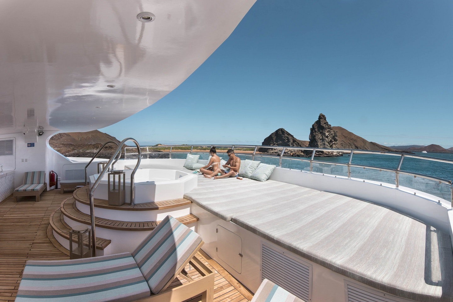 The deck of a yacht with two people on it.