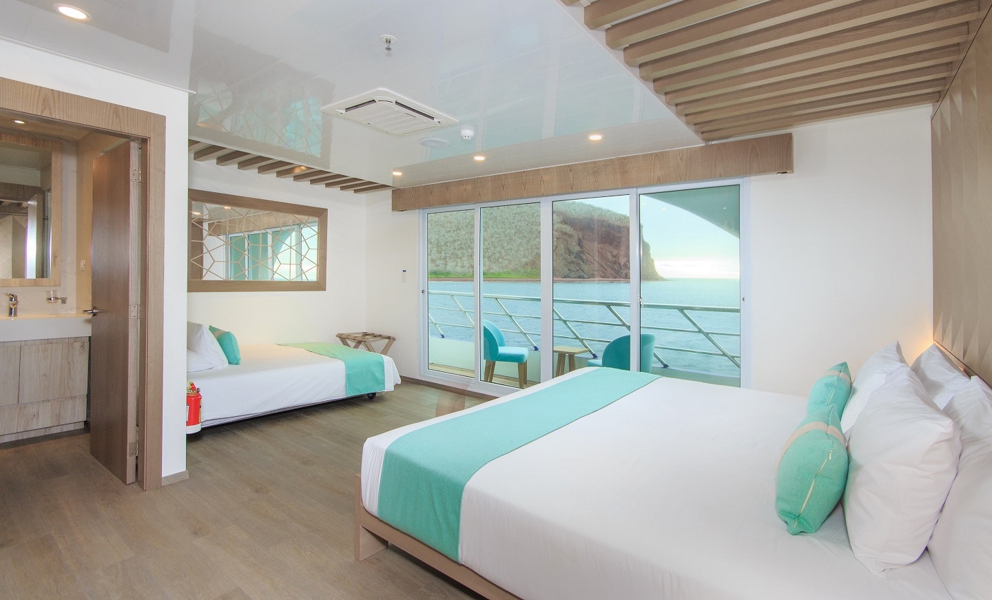 Two beds in a room with a view of the ocean.