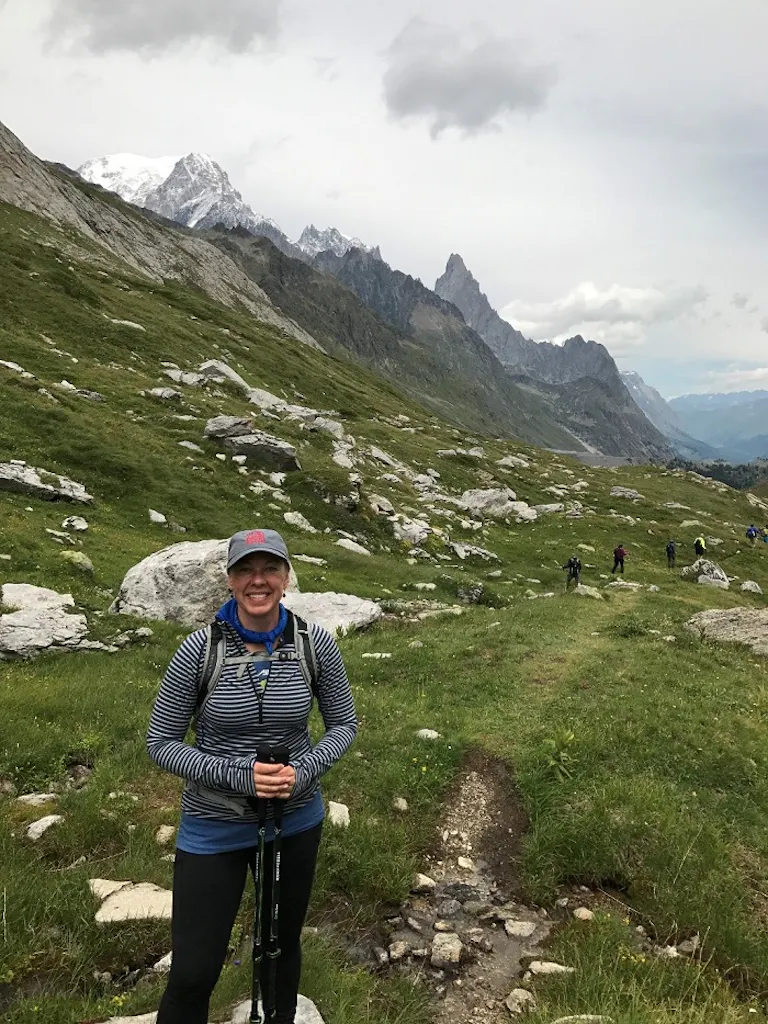 Woman in recreational hiking gear is posing for a photo
