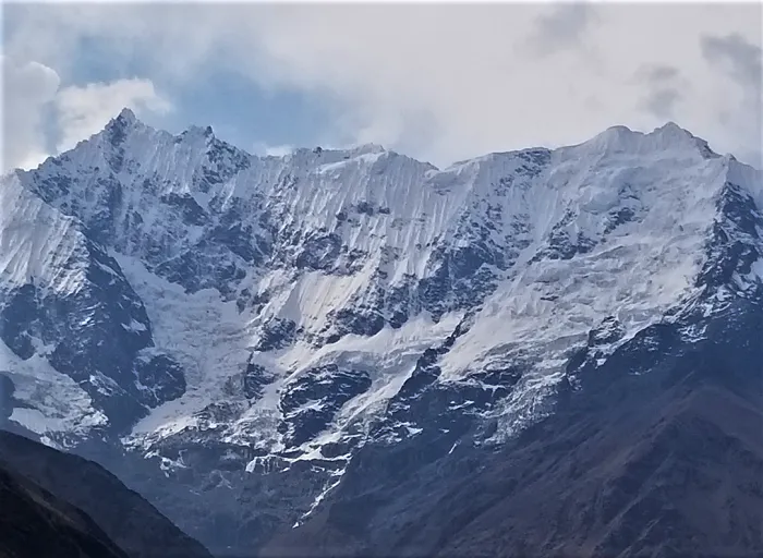 A mountain range with snow capped mountains in the background.