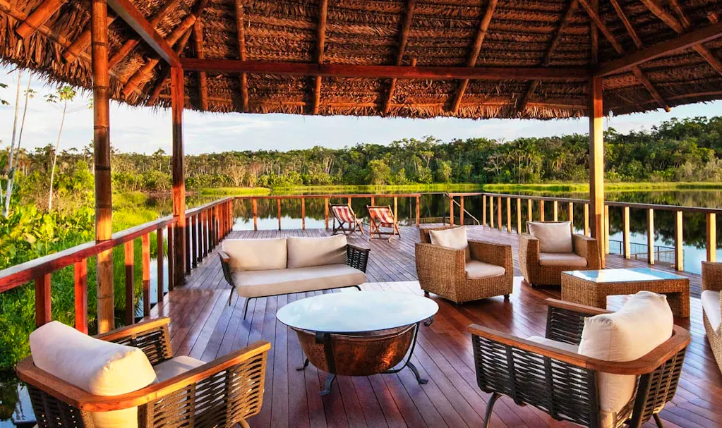 Extend your trip to Ecuador and relax on a wooden deck overlooking a lake with wicker furniture.
