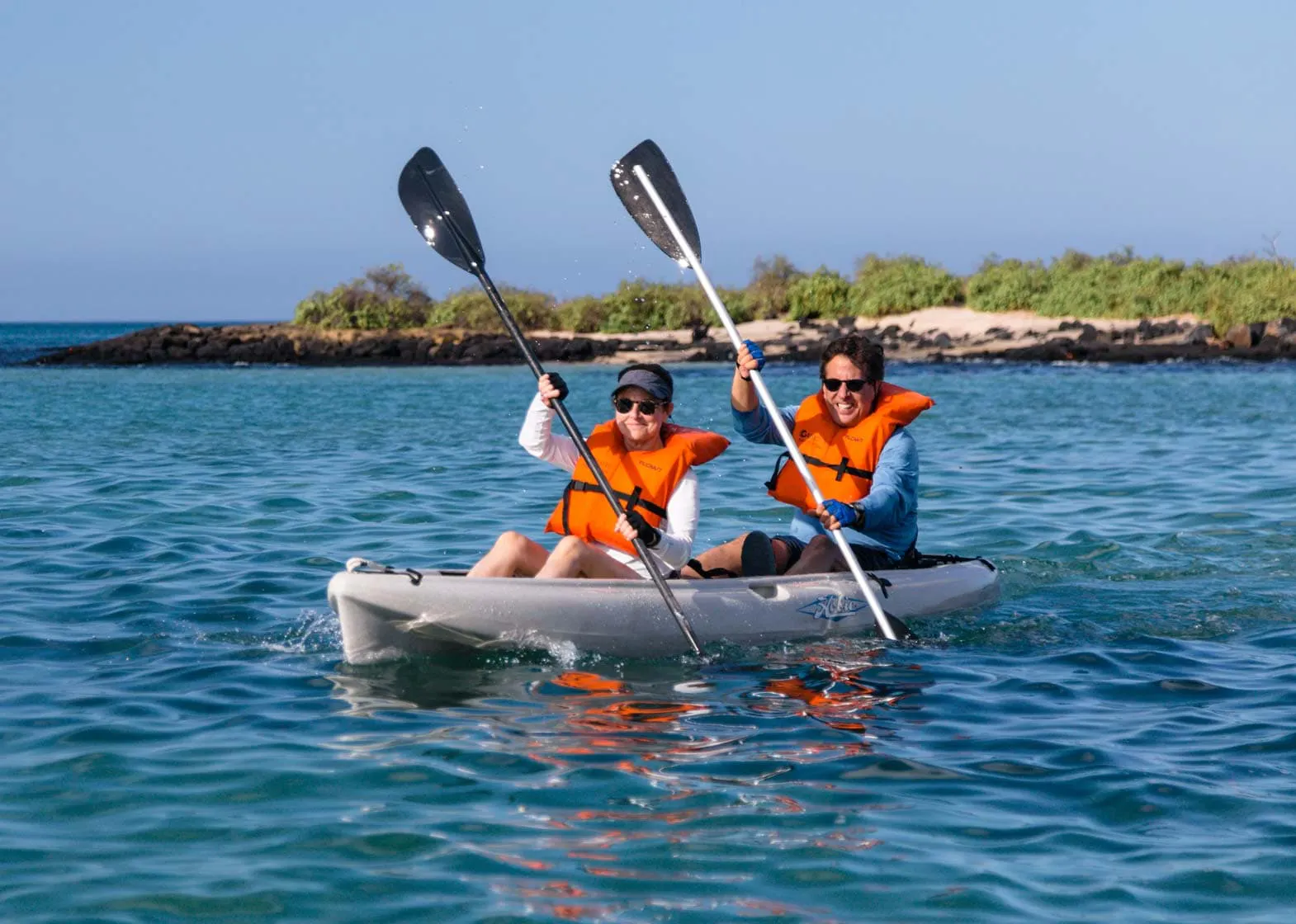 Two people explore the Galapagos Islands in a kayak.
