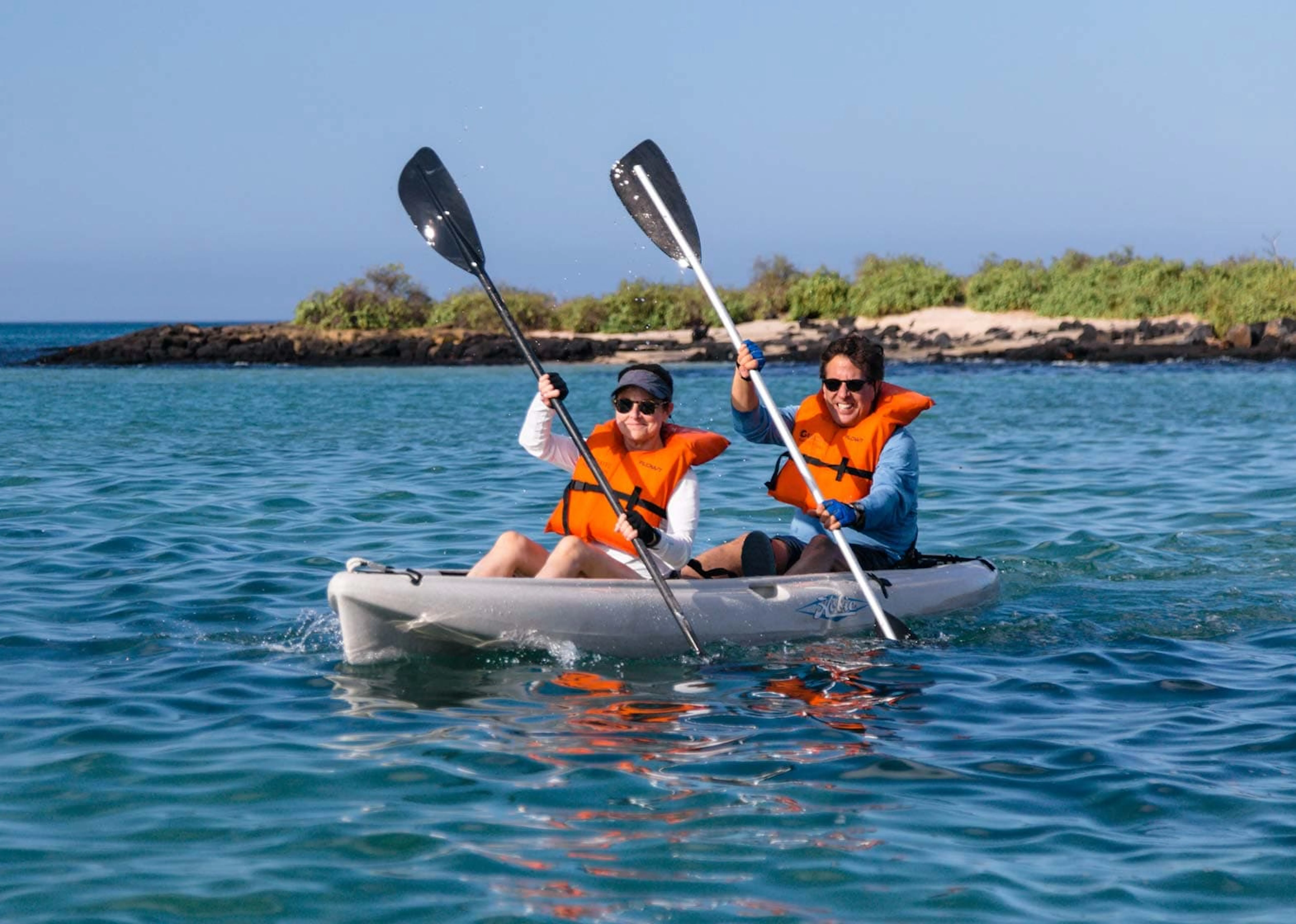 Two people explore the Galapagos Islands in a kayak.
