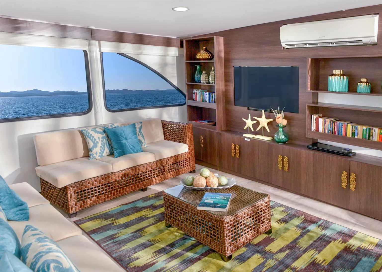 A living room on a boat with couches and a tv.