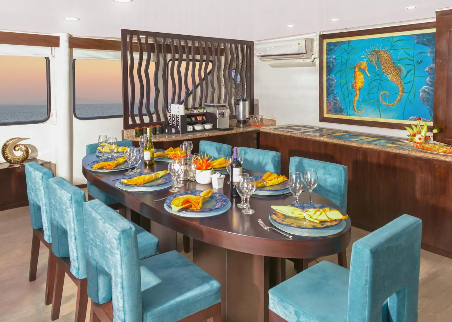 A dining room on a boat with a view of the ocean.