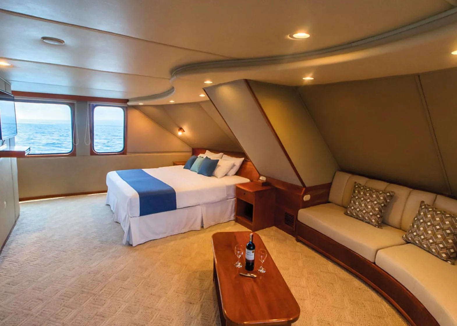 Integrity Adventure Tours offers a luxurious room on a boat, equipped with a comfortable bed, cozy couch, and a state-of-the-art TV.