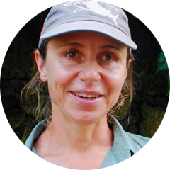 A woman in a green shirt with a hat.