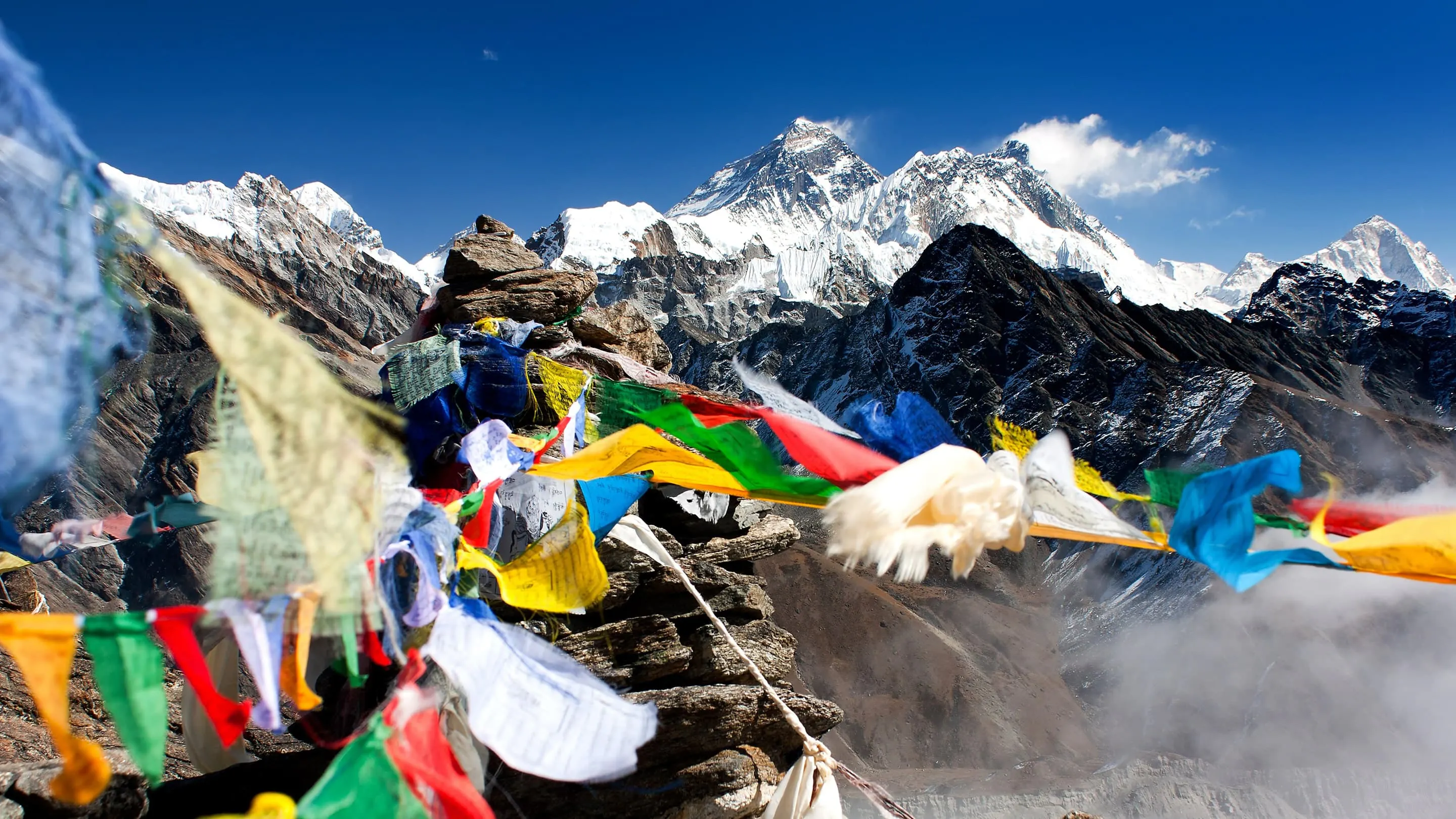 A group of prayer flags on top of a mountain.
