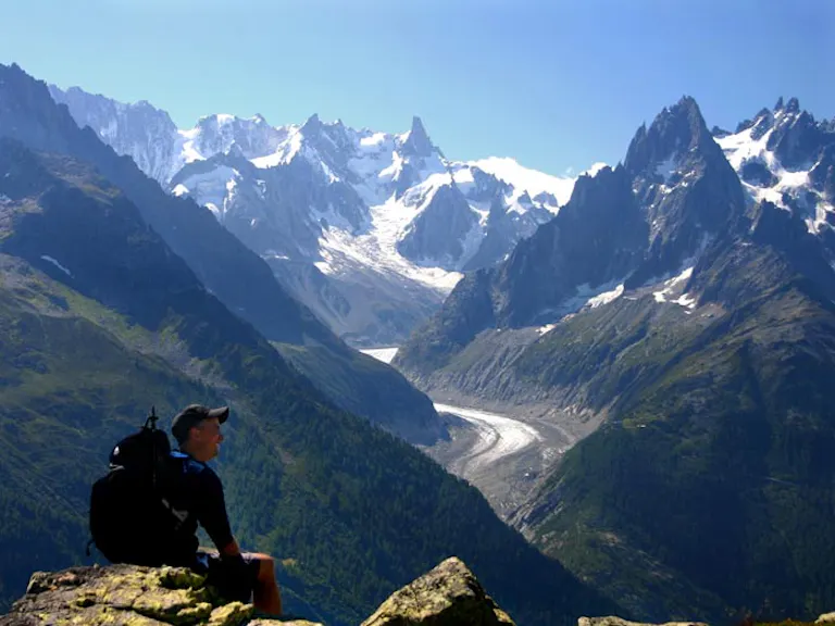 solo hiker looking at dazzling views in the Alps at Matterhorn or Mont Blanc massif