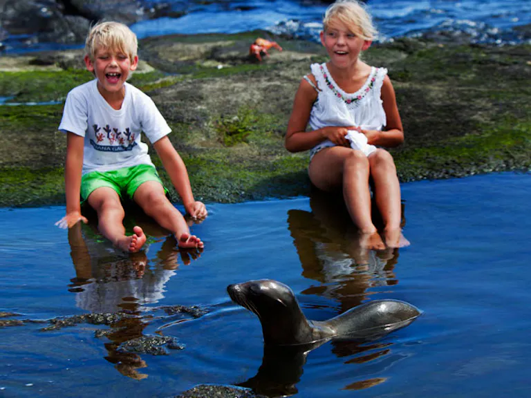 childen playing with playful sea lions
