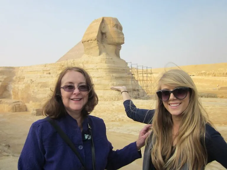 Two women posing in front of the sphinx in Egypt on a cultural discovery group tour