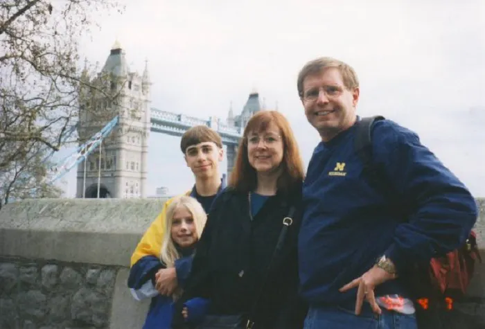 A family posing for a picture in front of tower bridge.