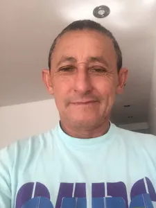 A man in a blue t - shirt is taking a selfie.
