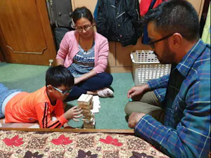 A group of people playing with wooden blocks in a room.